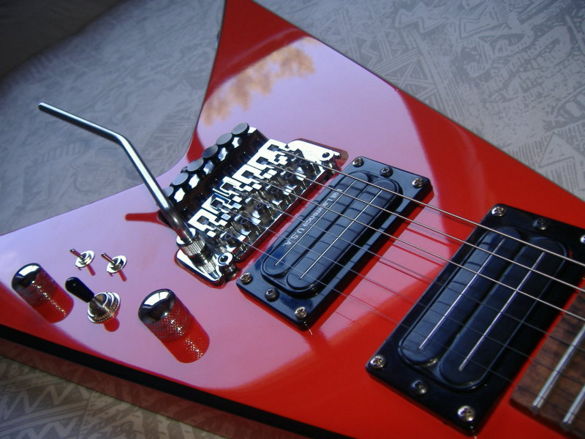 A Floyd Rose bridge installed in a custom made Flying V guitar.  Photo Credit